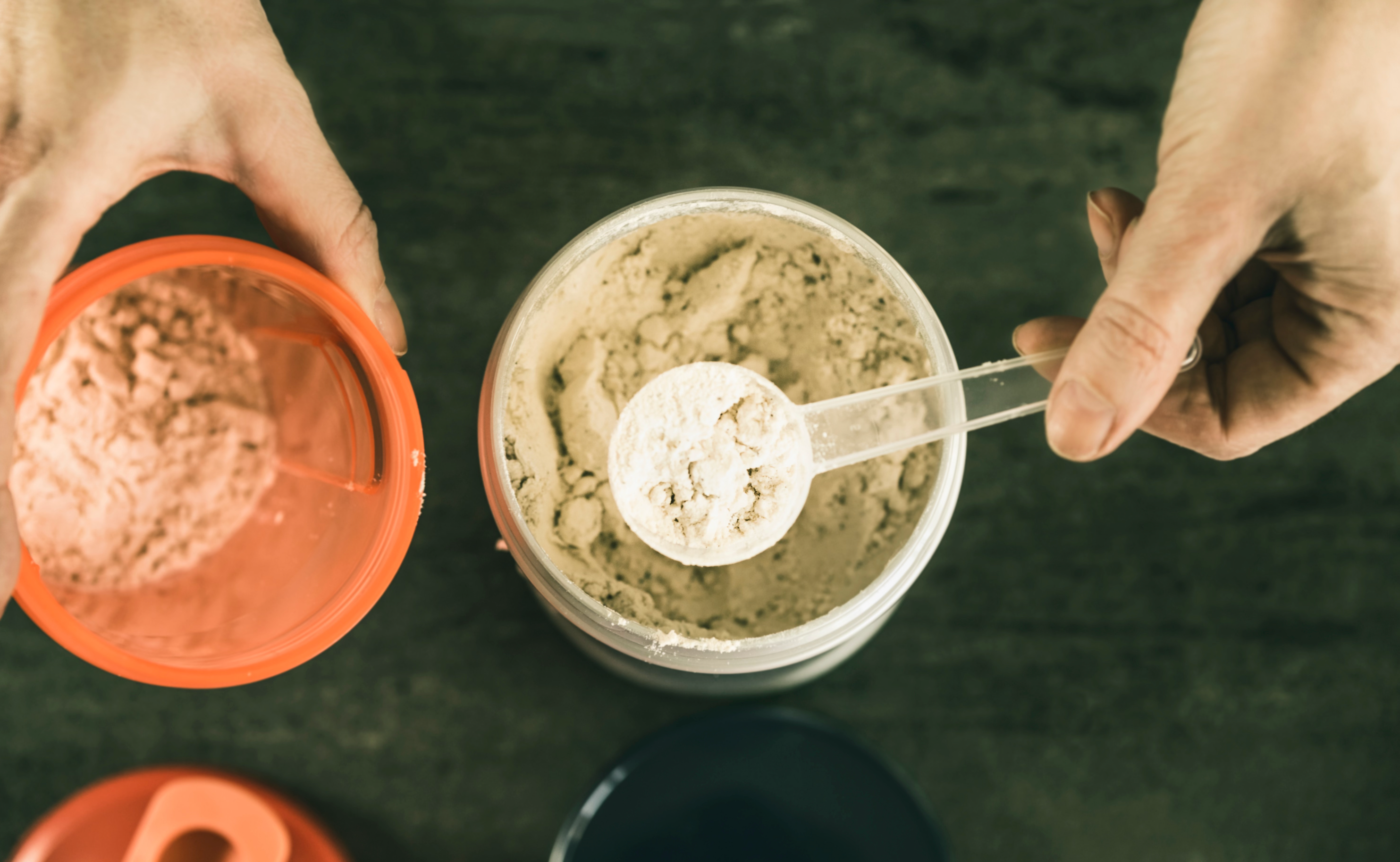 Image showing someone scooping creatine monohydrate into their shaker cup.